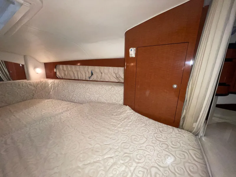 Slide: The Image of 2005 Sea Ray 300 Sundancer cabin interior with wood paneling and patterned bedding. - 29