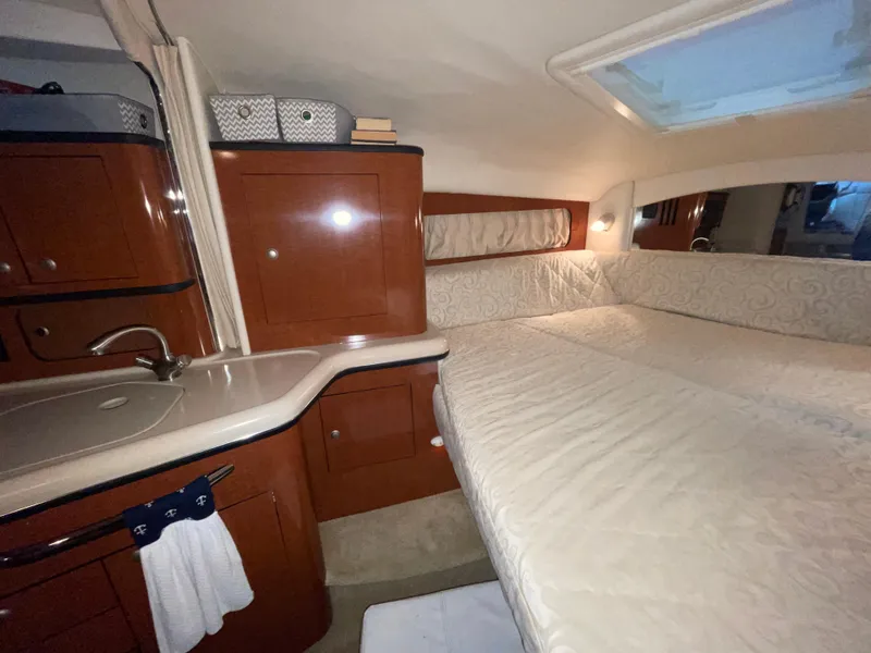 Slide: The Image of 2005 Sea Ray 300 Sundancer cabin interior with bed, sink, and storage cabinets. - 30