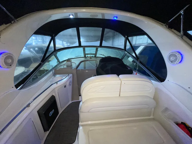 Slide: The Image of 2005 Sea Ray 300 Sundancer interior with white seating and modern dashboard. - 7