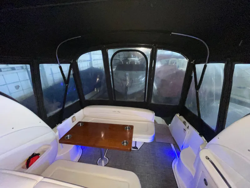 Slide: The Image of Interior of 2005 Sea Ray 300 Sundancer with seating and table, under a black canopy. - 8