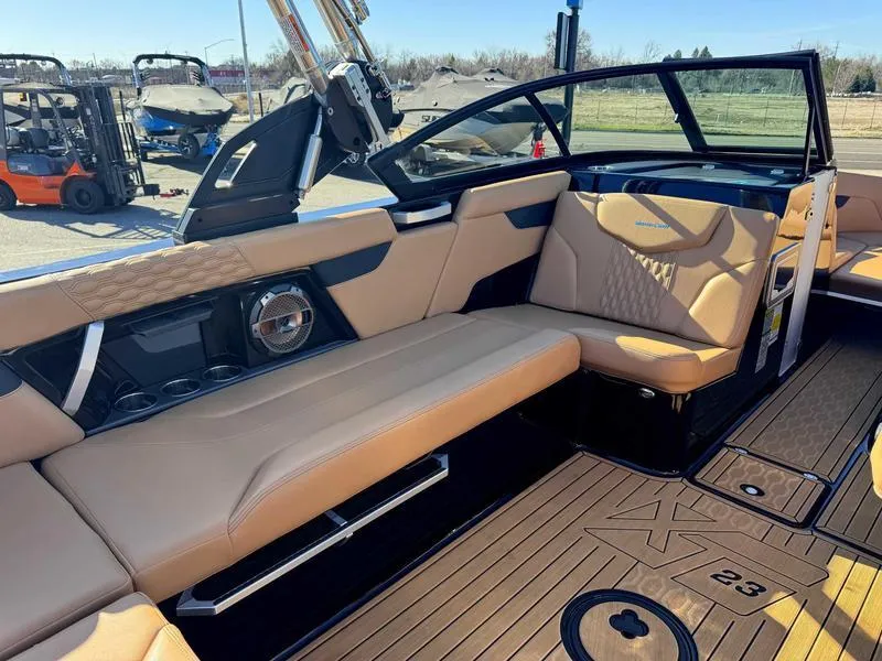 Slide: The Image of 2022 MasterCraft XT23 boat interior with tan seating and modern design. - 10
