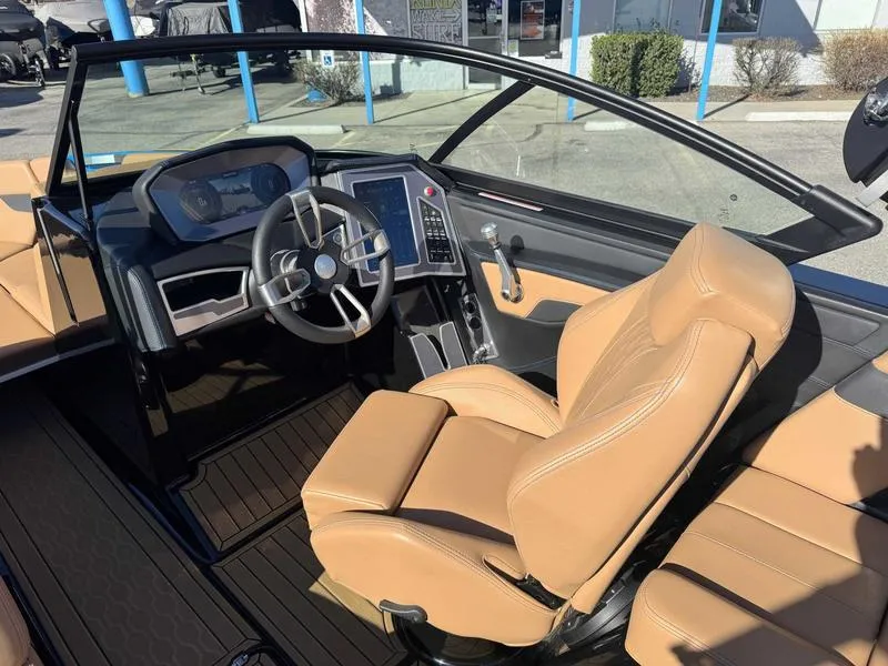 Slide: The Image of 2022 MasterCraft XT23 boat interior with tan leather seats and modern dashboard. - 11
