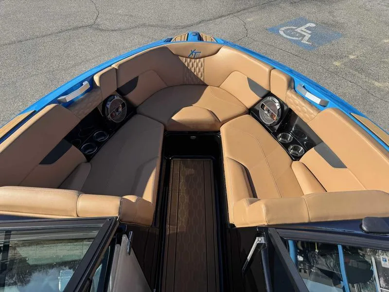 Slide: The Image of 2022 MasterCraft XT23 boat interior with tan seating and blue accents. - 14