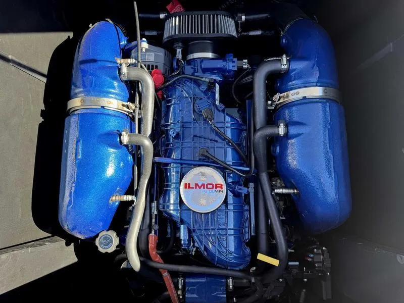 Slide: The Image of Engine of a 2022 MasterCraft XT23 boat with blue components and Ilmor branding. - 17