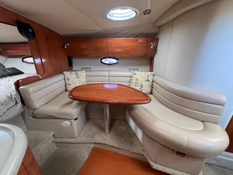Slide: The Image of 2007 Larson Cabrio 350 interior with beige leather seating and wooden table. - 11