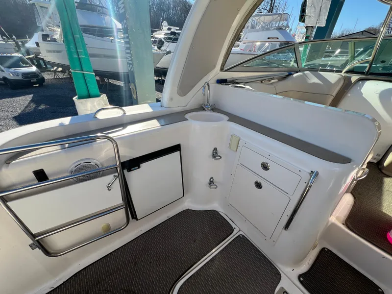 Slide: The Image of 2007 Larson Cabrio 350 boat interior with kitchenette and storage compartments. - 2