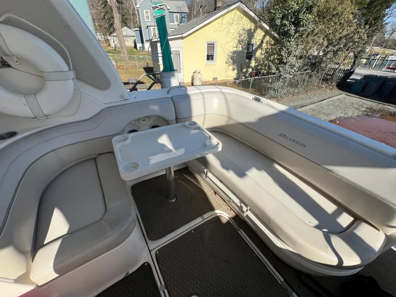 Slide: The Image of 2007 Larson Cabrio 350 boat interior with seating and table, outdoor setting. - 3