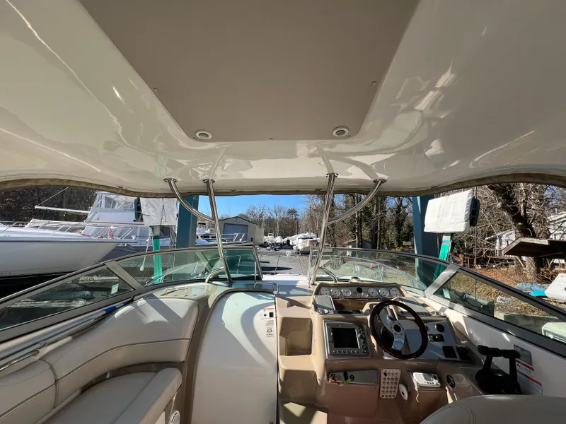 Slide: The Image of 2007 Larson Cabrio 350 boat interior with steering wheel and dashboard, docked outdoors. - 5