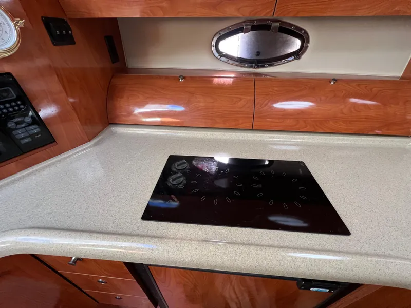 Slide: The Image of 2007 Larson Cabrio 350 yacht kitchen with sleek countertop and modern stovetop. - 9