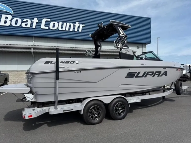 Slide: The Image of 2020 Supra SL450 boat on trailer at dealership, featuring sleek design and modern features. - 2