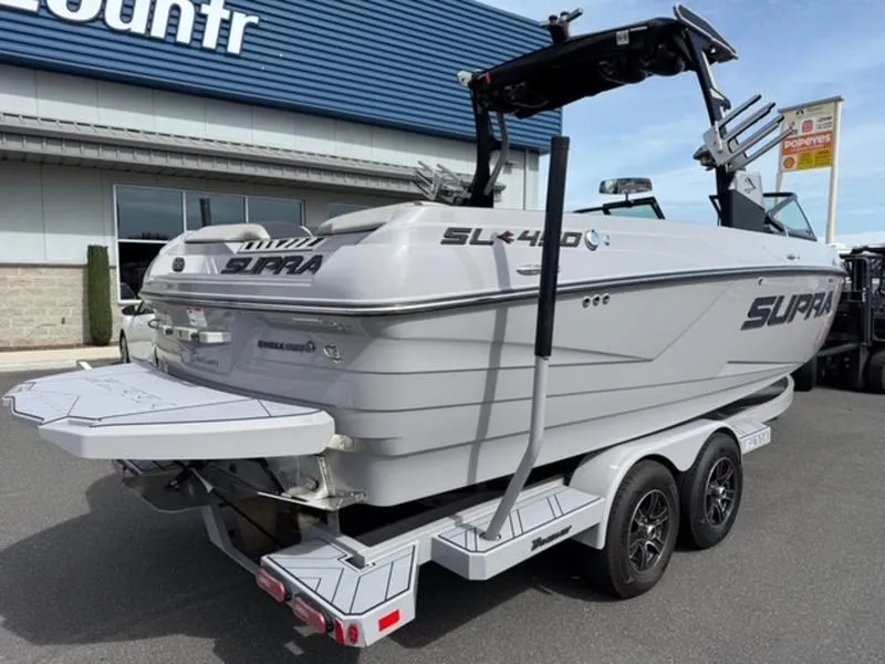 Slide: The Image of 2020 Supra SL450 boat on trailer, parked outside a building. - 4