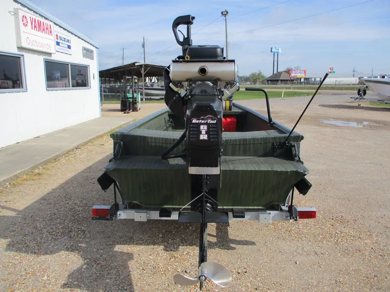 Slide: The Image of 2025 Gator Tail 1754 Extreme boat with outboard motor, parked outside dealership. - 5