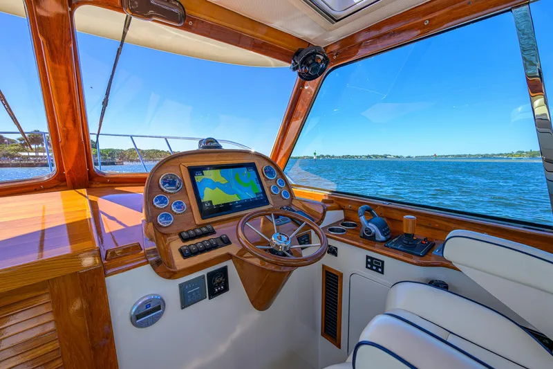 Slide: The Image of Helm of 2010 Hinckley Picnic Boat 37 MKIII with navigation system, overlooking serene waters. - 12