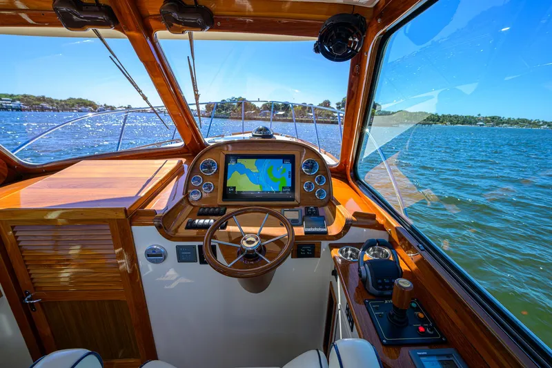 Slide: The Image of Helm of 2010 Hinckley Picnic Boat 37 MKIII with navigation system, steering wheel, and scenic water view. - 15