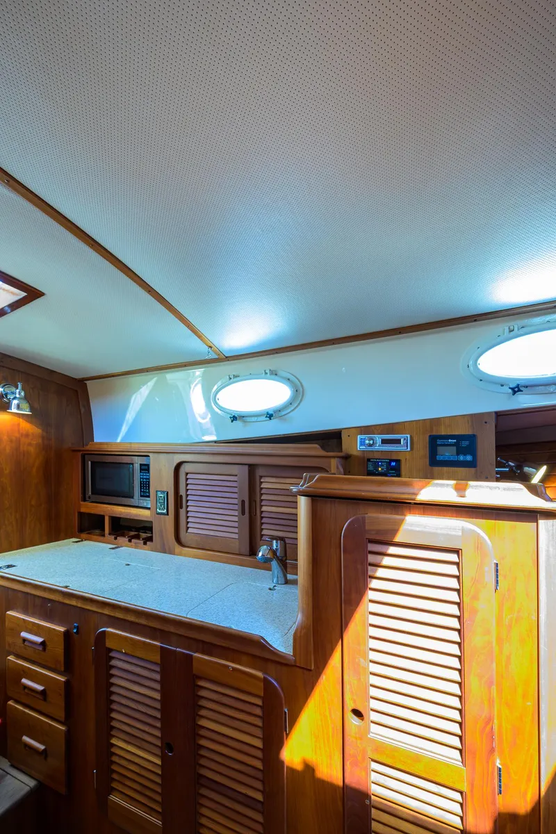 Slide: The Image of Interior of 2010 Hinckley Picnic Boat 37 MKIII with wooden cabinetry and porthole windows. - 17