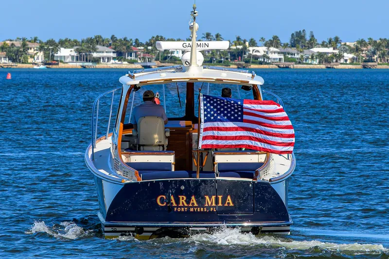 Slide: The Image of Hinckley Picnic Boat 37 MKIII, 2010, cruising with American flag, coastal background. - 2
