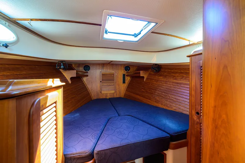 Slide: The Image of Cozy cabin interior of 2010 Hinckley Picnic Boat 37 MKIII with wooden paneling and blue cushions. - 20
