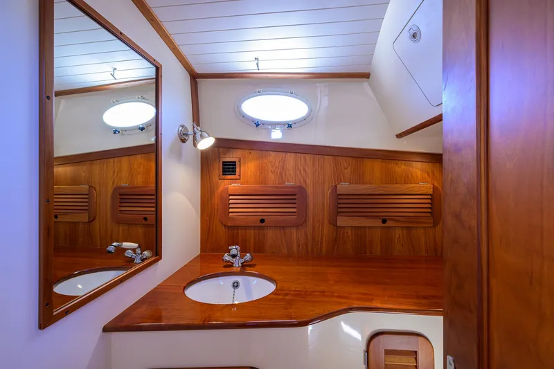 Slide: The Image of Elegant wooden interior of 2010 Hinckley Picnic Boat 37 MKIII bathroom with sink and mirror. - 22