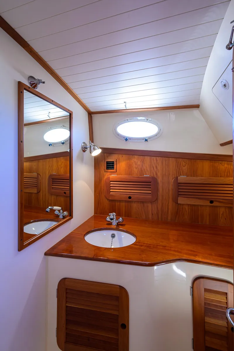 Slide: The Image of Hinckley Picnic Boat 37 MKIII 2010 bathroom with wooden cabinetry and round sink. - 23