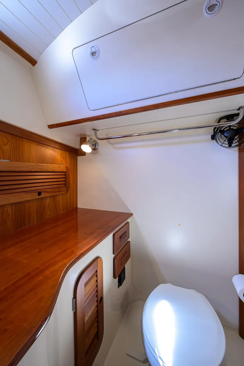 Slide: The Image of 2010 Hinckley Picnic Boat 37 MKIII interior with wooden cabinetry and compact bathroom. - 24