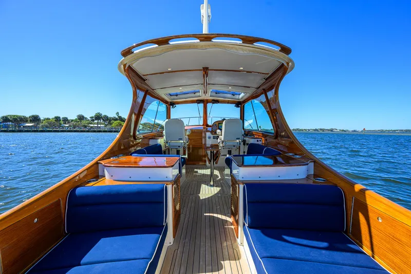 Slide: The Image of Hinckley Picnic Boat 37 MKIII, 2010 model, featuring elegant wooden interior and blue seating on open water. - 8