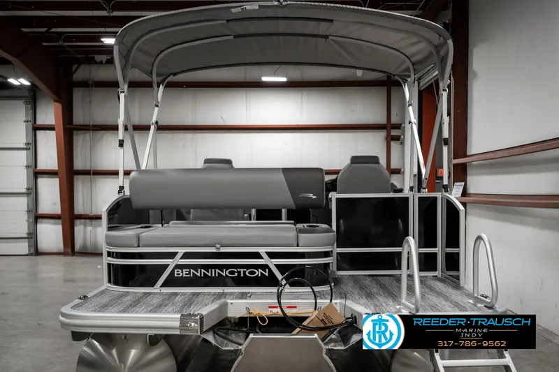 Slide: The Image of 2025 Bennington 21 SSB pontoon boat in a showroom, featuring sleek design and canopy. - 6