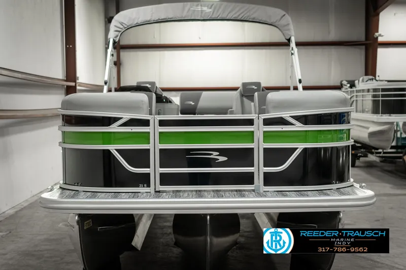 Slide: The Image of 2025 Bennington 21 SSB pontoon boat in showroom, featuring sleek design and green accents. - 8