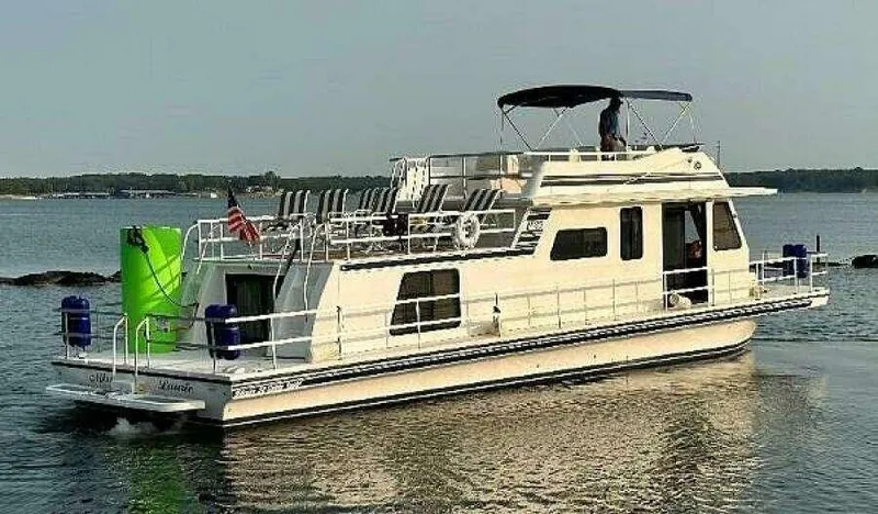 Slide: The Image of 2004 Gibson 50 Houseboat on calm water with upper deck seating and canopy. - 0