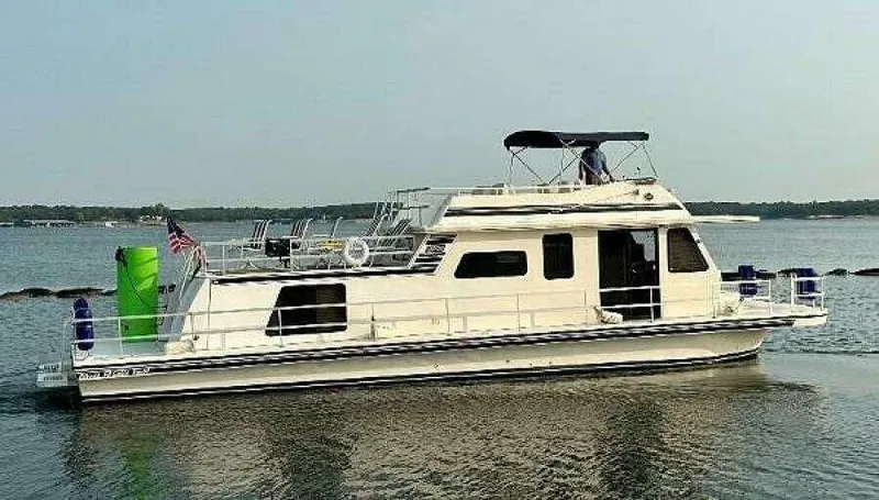 Slide: The Image of 2004 Gibson 50 Houseboat on calm water with upper deck and canopy. - 1