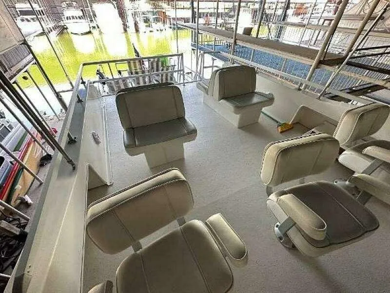 Slide: The Image of 2004 Gibson 50 Houseboat interior with seating area and marina view. - 14