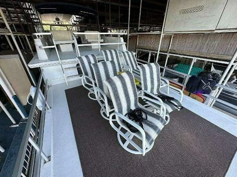 Slide: The Image of 2004 Gibson 50 Houseboat deck with striped lounge chairs and a carpeted area. - 17