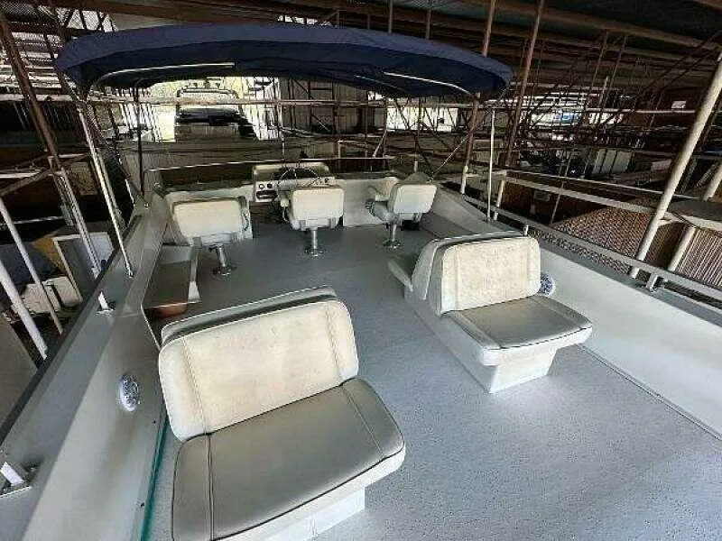 Slide: The Image of 2004 Gibson 50 Houseboat interior with seating and canopy in a docked setting. - 19