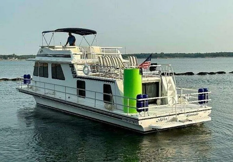 Slide: The Image of 2004 Gibson 50 Houseboat cruising on calm water with upper deck seating. - 4