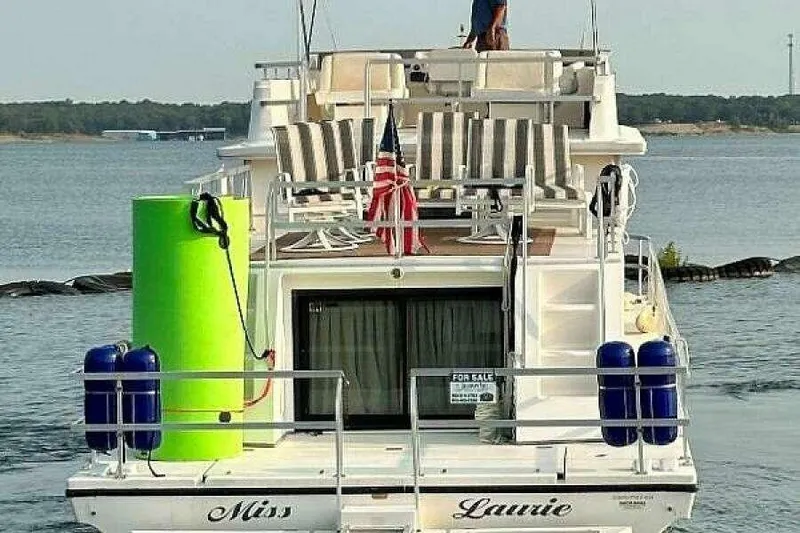 Slide: The Image of 2004 Gibson 50 Houseboat with striped chairs and American flag on deck. - 5