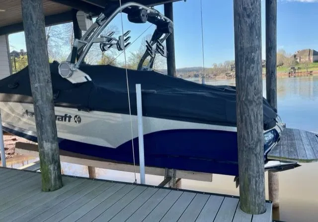 Slide: The Image of 2019 MasterCraft X22 boat covered and docked on a lake. - 13