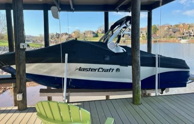 Slide: The Image of 2019 MasterCraft X22 boat covered and docked by a lakeside. - 14
