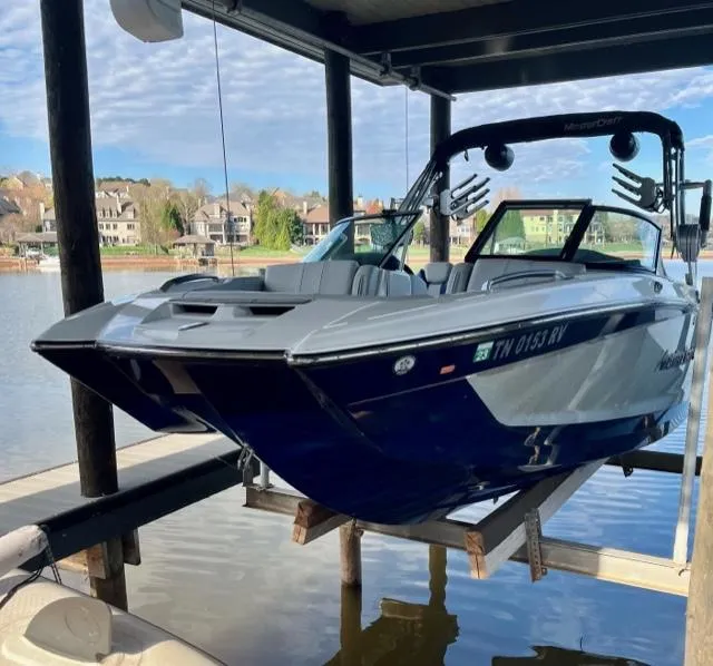 Slide: The Image of 2019 MasterCraft X22 boat on lift, docked by a scenic lakeside. - 3