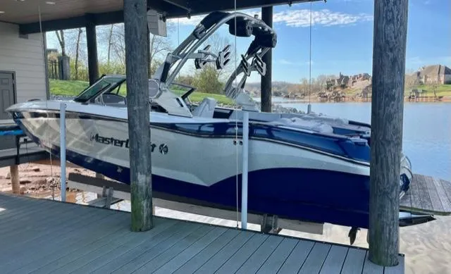 Slide: The Image of 2019 MasterCraft X22 boat docked in a lakeside boathouse. - 4