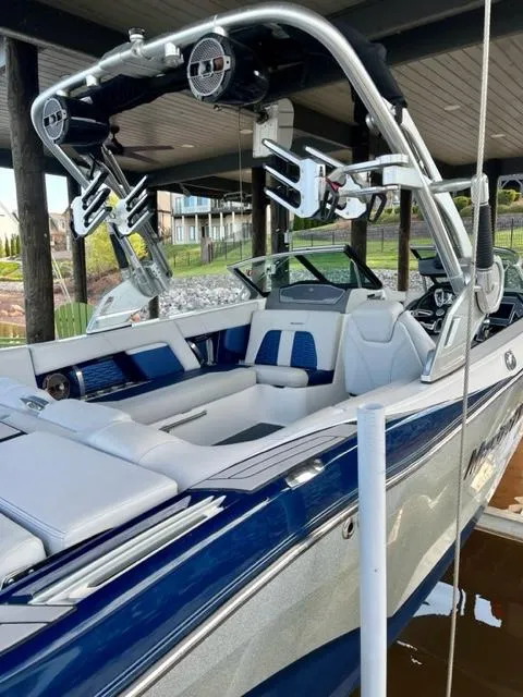 Slide: The Image of 2019 MasterCraft X22 boat with blue and white interior, docked under a covered area. - 5