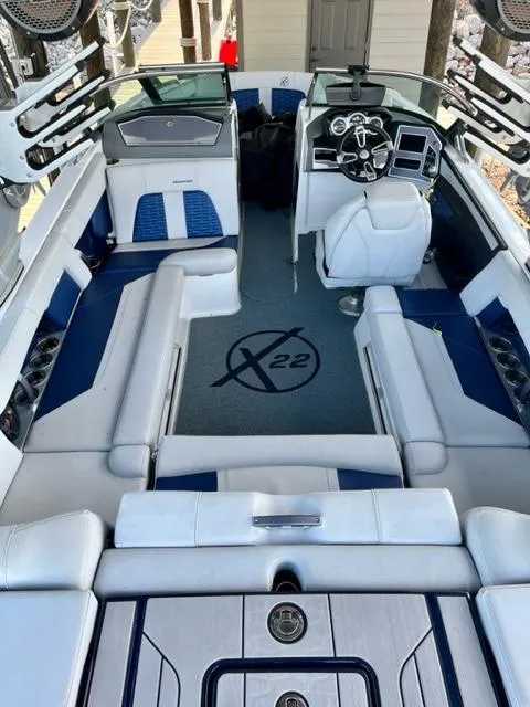 Slide: The Image of 2019 MasterCraft X22 boat interior with white and blue seating, advanced dashboard, and spacious layout. - 7