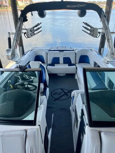 Slide: The Image of 2019 MasterCraft X22 boat interior with seating and wakeboard tower, docked by the water. - 8