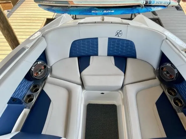 Slide: The Image of 2019 MasterCraft X22 boat interior with blue and white seating and cup holders. - 9