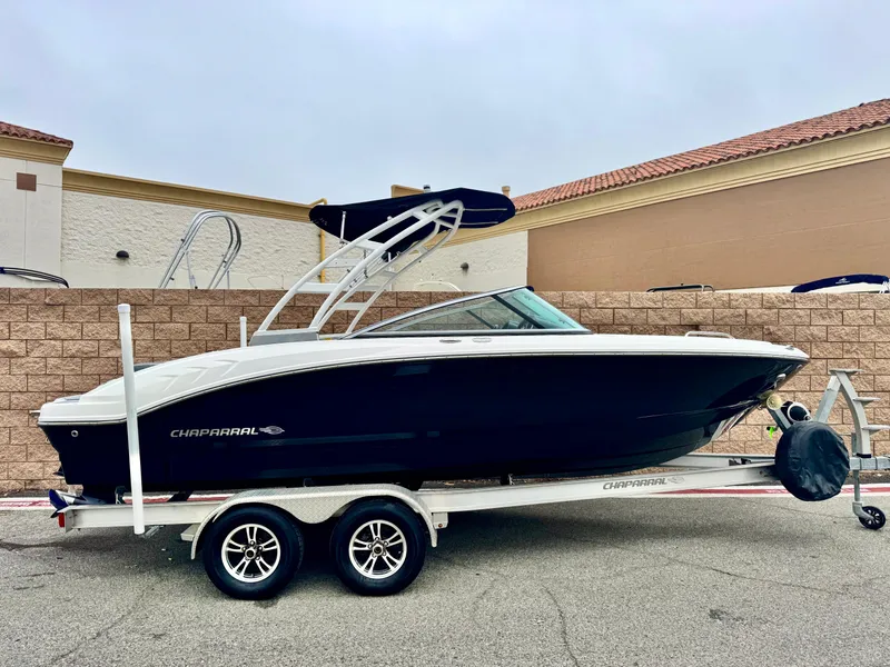 Slide: The Image of 2021 Chaparral 21 SSi boat on trailer, black hull, parked outdoors. - 0