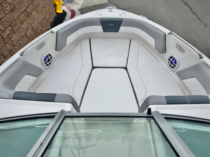 Slide: The Image of 2021 Chaparral 21 SSi boat interior with white and gray seating, featuring built-in speakers. - 12
