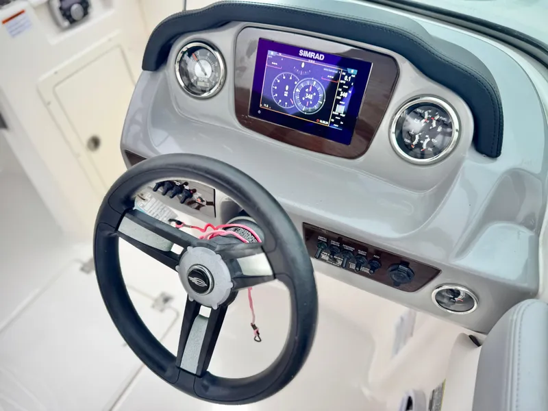 Slide: The Image of 2021 Chaparral 21 SSi boat dashboard with steering wheel and digital display. - 29