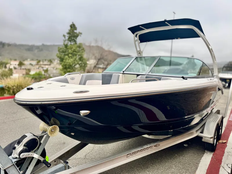 Slide: The Image of 2021 Chaparral 21 SSi boat on trailer, sleek design, parked outdoors. - 3