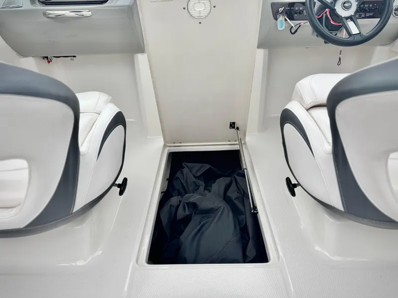 Slide: The Image of 2021 Chaparral 21 SSi boat interior with open storage compartment between two seats. - 31