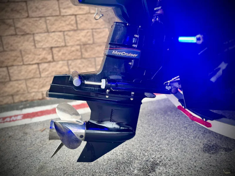 Slide: The Image of 2021 Chaparral 21 SSi boat with MerCruiser outdrive and propeller, illuminated by blue light. - 6