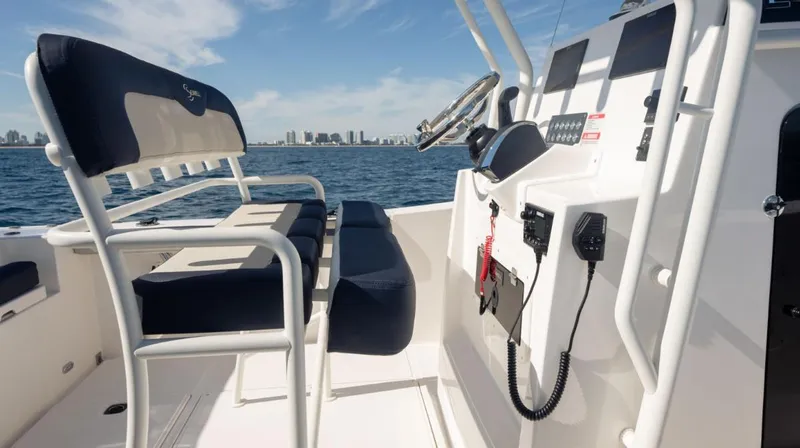 Slide: The Image of 2024 SeaWell 240CC boat interior with seating and control panel, ocean view in background. - 15