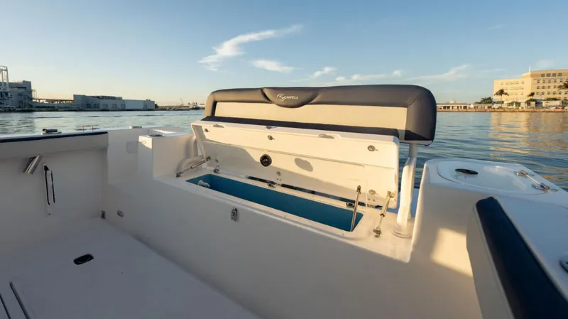 Slide: The Image of 2024 SeaWell 240CC boat with open storage compartment, docked at sunset. - 20